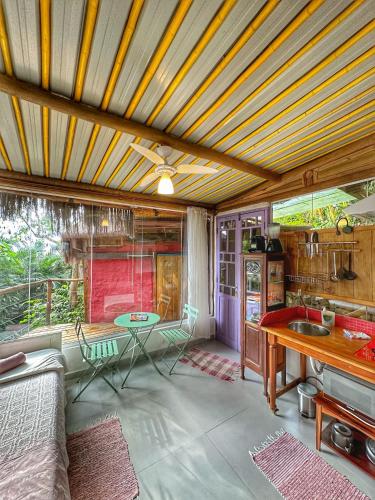 a living room with a table and a kitchen at Casas D'Água Doce - Casa Luz in Ilhabela