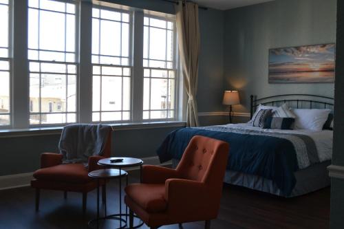 a bedroom with a bed and two chairs at The Lofts at GFC in Galveston