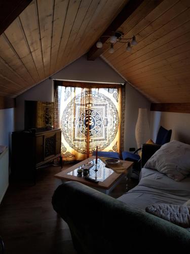 ein Wohnzimmer mit einem Sofa, einem Tisch und einem Fenster in der Unterkunft Ferienwohnung Namaste in Langenargen