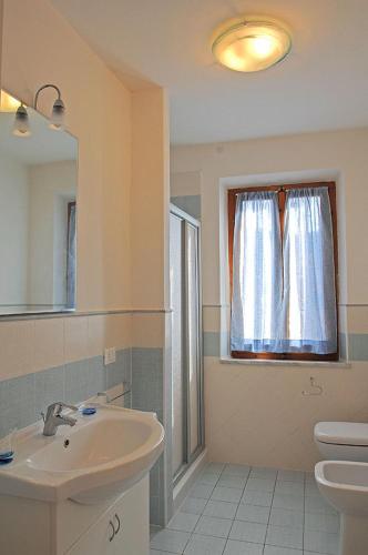 a bathroom with a sink and a toilet and a window at Appartamenti Casa Pineta in Marina di Campo