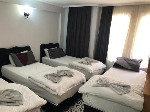 a room with three beds with towels on them at Reydel Hotel in Istanbul