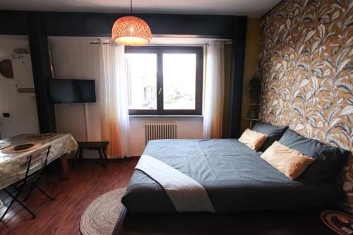 a bedroom with a bed and a window and a table at Zen House in Cormano