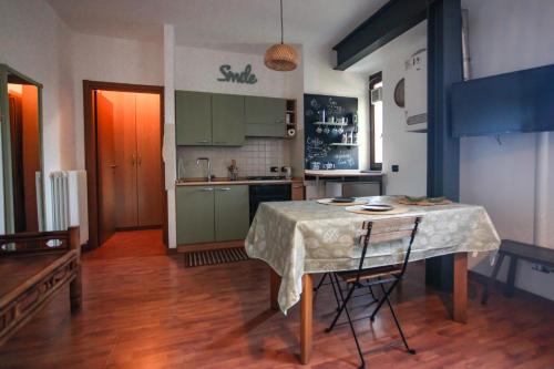 科爾馬諾的住宿－Zen House，厨房配有绿色橱柜和桌椅