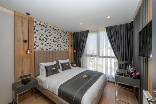 um quarto com uma cama grande e uma janela grande em Heaven Inn Airport Hotel em Arnavutköy