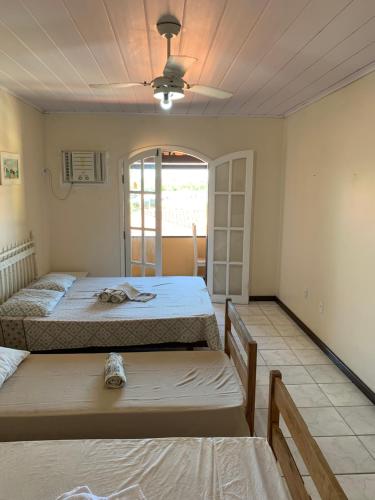 1 Schlafzimmer mit 2 Betten und einer Decke in der Unterkunft ALOHA LAGOON CABO FRIO in Cabo Frio