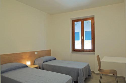 a hospital room with two beds and a window at Appartamenti Casa Pineta in Marina di Campo