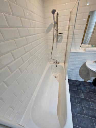 a bathroom with a bath tub and a sink at 65 Renfield st 2 bed Apartment in Glasgow