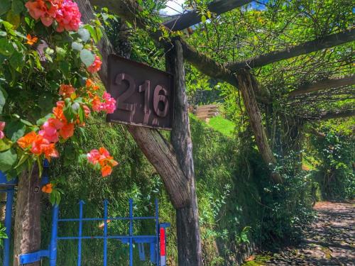 a sign on the side of a house with flowers at Casas D'Água Doce - Casa Luz in Ilhabela