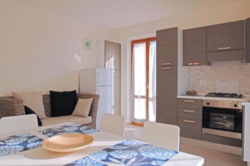 a kitchen and living room with a table and chairs at Appartamenti Casa Pineta in Marina di Campo