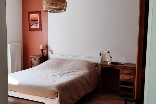 a bedroom with a bed and a desk and a lamp at Ty ravissant - Les Gîtes de la Côte d'Amour in Le Croisic