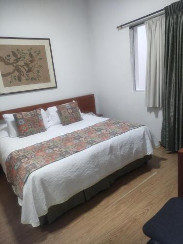 a bedroom with a bed in a room with a window at Hotel Bella Montaña in Manizales