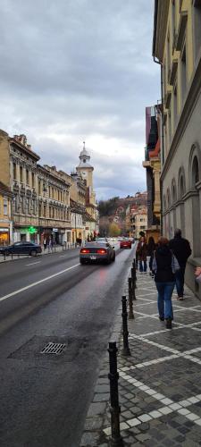 a group of people walking down a city street at Casa Chiper - Attic apartment with view in Braşov