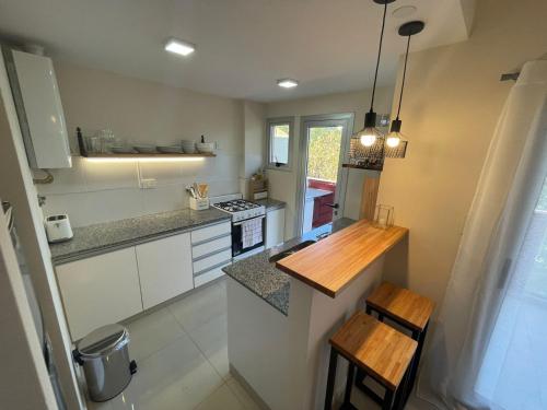 a kitchen with white cabinets and a wooden counter top at PASO SQUARE in La Plata
