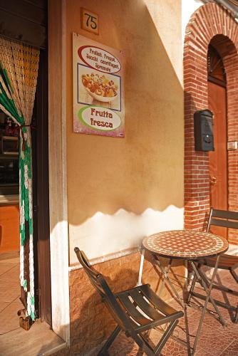 a table and chairs and a sign on the side of a building at BELVEDERE Appartamento per vacanze in Castel di Iudica