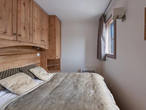a bedroom with a bed and a wooden cabinet at Charmant appartement cosy au centre de Val Thorens avec WiFi - FR-1-640-20 in Val Thorens
