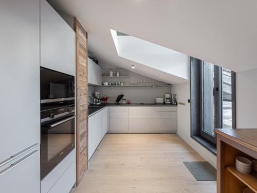 une cuisine avec des placards blancs et une grande fenêtre dans l'établissement Appartement familial neuf à Courchevel près des commerces et pistes - FR-1-562-65, à Courchevel