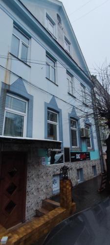 a large white house with stairs in front of it at Гостевая комната in Chernivtsi