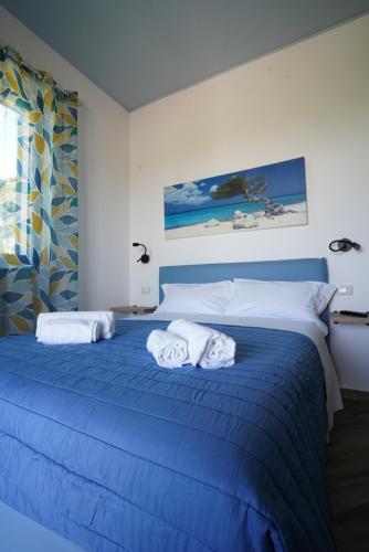 a bedroom with a blue bed with towels on it at Casale Ferrantino in Giulianova
