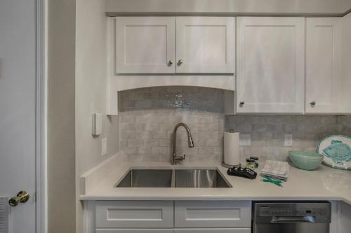 a kitchen with a sink and white cabinets at The Cove 205B by Vacation Homes Collection in Gulf Shores