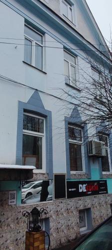a white house with a sign on the side of it at Гостевая комната in Chernivtsi