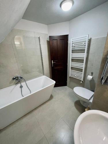 ein Badezimmer mit Badewanne, Toilette und Waschbecken in der Unterkunft Forest Resort in Băile Tuşnad
