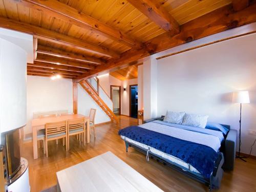 1 dormitorio con cama y mesa de comedor en Elegante Ático Encamp - FREE Parking Wifi SmartTv - Con altillo y 2 baños completos!, en Encamp