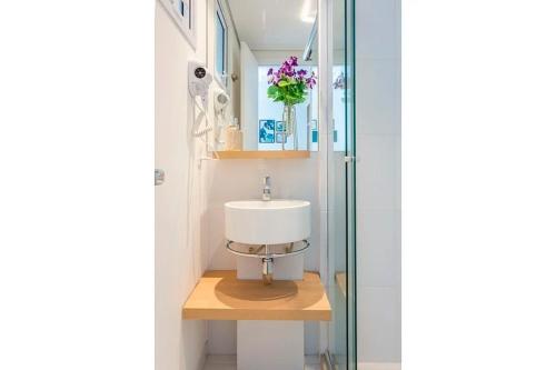 a bathroom with a sink and a glass shower at Studio Harmonia, Moderno, Aconchegante e com Garagem in Sao Paulo