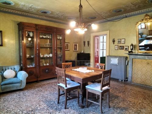 a dining room with a wooden table and chairs at Giò's House vintage style in Stresa