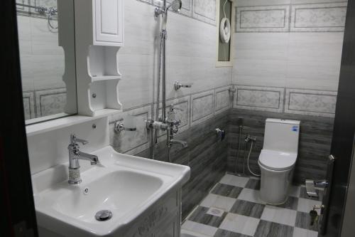 a bathroom with a sink and a toilet at Marina H in Sohar