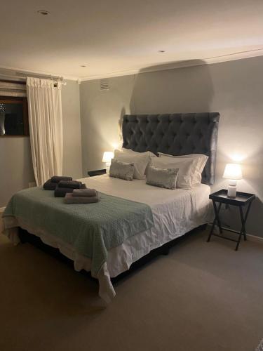 1 dormitorio con 1 cama grande y cabecero grande en 43 on Ophir, en Ciudad del Cabo