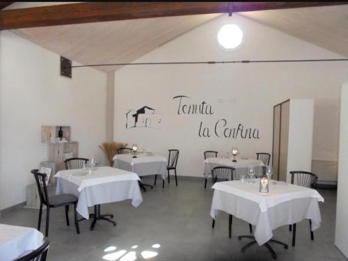 un comedor con mesas y sillas blancas y un cartel en la pared en TENUTA LA CONFINA, 