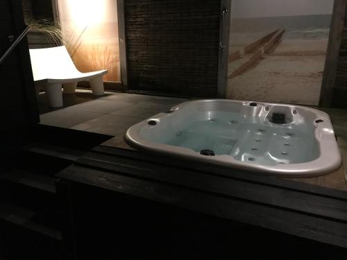 uma banheira de hidromassagem numa casa de banho com janela em Zeeuws Ontspannen Bed & Wellness em Middelburg