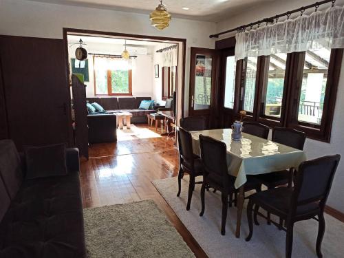 a dining room and living room with a table and chairs at Villa River Pehchevo in Pehčevo
