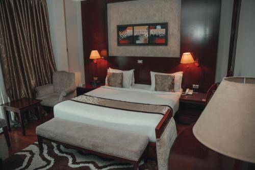 a hotel room with two beds and a chair at Sidra International Hotel in Addis Ababa