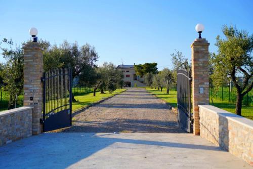 a gate to a driveway with a house in the background at Casale Ferrantino in Giulianova