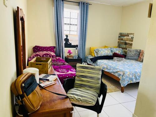 a bedroom with a bed and a table with a chair at Nouvelle Orange Willemstad in Willemstad