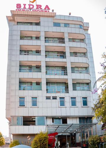 a tall white building with a sign on it at Sidra International Hotel in Addis Ababa