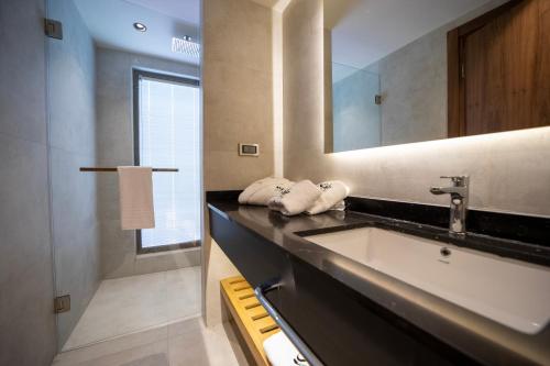 ein Bad mit einem Waschbecken und einem Spiegel in der Unterkunft Sezz Hotels Spa Wellness Yalikavak Adult Only in Yalıkavak