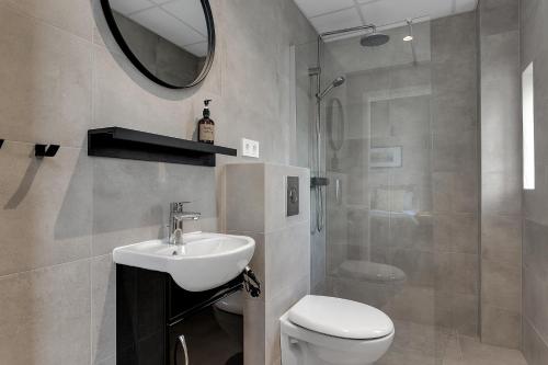 a bathroom with a sink and a toilet and a mirror at NN Urban Guesthouse in Reykjavík