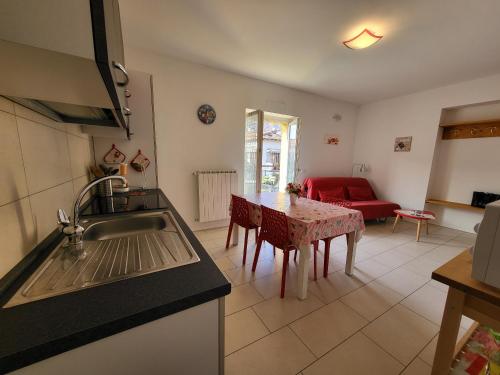 a kitchen and living room with a table and a couch at Red Apartment - Residenza Silvana in Verbania