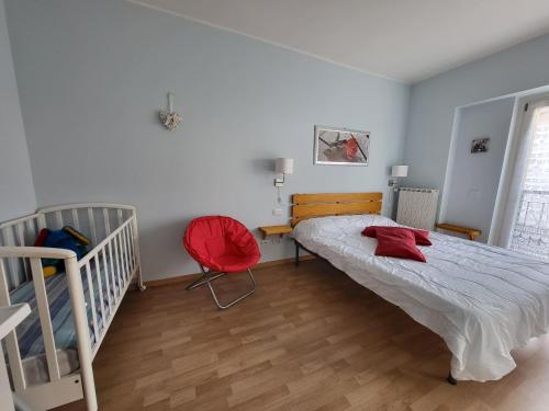 a bedroom with a large bed and a red chair at Red Apartment - Residenza Silvana in Verbania