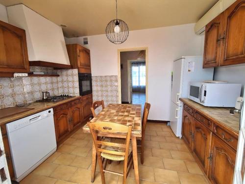 a kitchen with a table with chairs and a microwave at Chez Nelly in La Seyne-sur-Mer