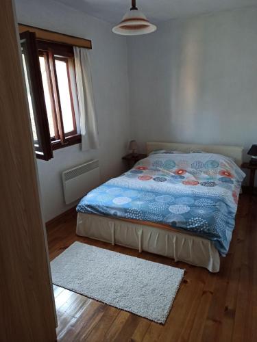 a bedroom with a bed and a window and a rug at Villa River Pehchevo in Pehčevo