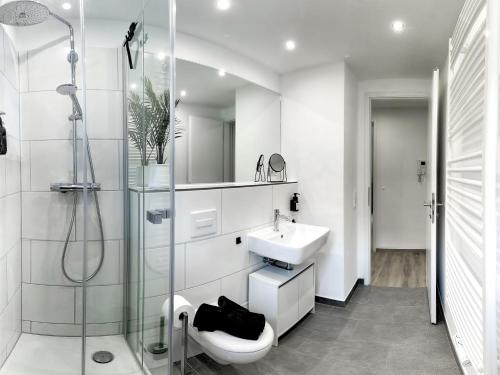 a white bathroom with a sink and a shower at LIGHTPLACE • Design • Boxspring • Balkon • 2 Smart TV •Innenstadt in Braunschweig