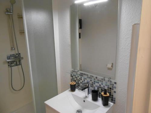 une salle de bain avec un lavabo, une douche et un miroir dans l'établissement Appartement à la plage, à Argelès-sur-Mer