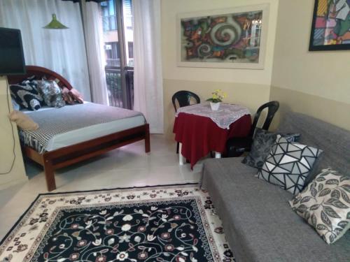ein Wohnzimmer mit einem Sofa und einem Tisch in der Unterkunft Loft Condado em Sahy - Mangaratiba in Mangaratiba