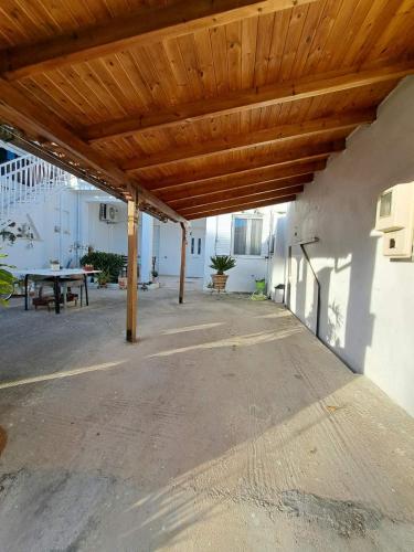 a patio with a wooden roof with a picnic table at Persefoni's Room in Néa Kíos