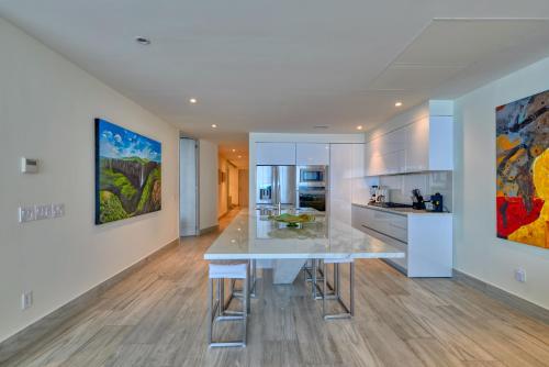 a kitchen with a large white table in a room at Maxwell Residences at Indah in Puerto Vallarta