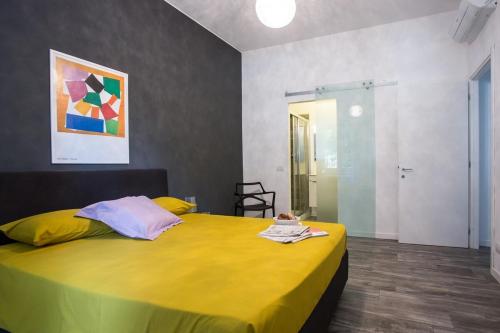 ミラノにあるAppartamento Washington 84のベッドルーム1室(大型ベッド1台、黄色い毛布付)