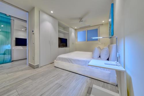 a bedroom with a white bed and a desk at Maxwell Residences at Indah in Puerto Vallarta
